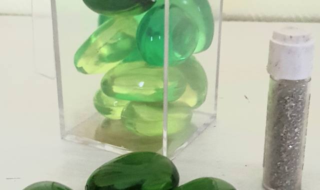 Divers galets décoratifs verts + tube de paillettes argent