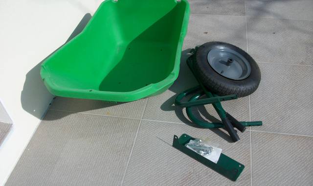 Jardinage une brouette neuve et une petite table ronde en métal vert