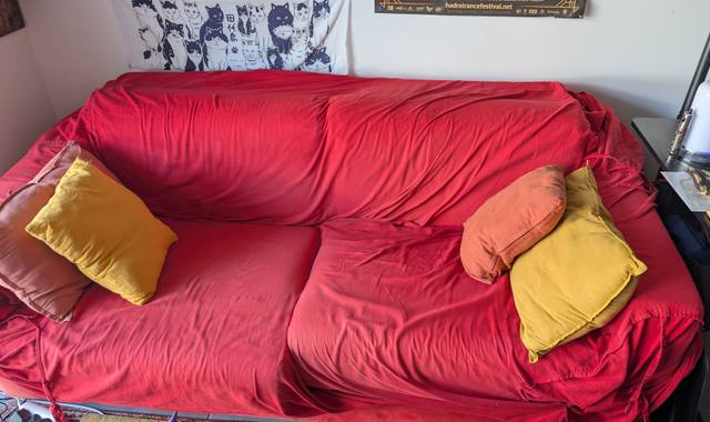 Meubles canapé rouge convertible en lit deux places avec ses coussins