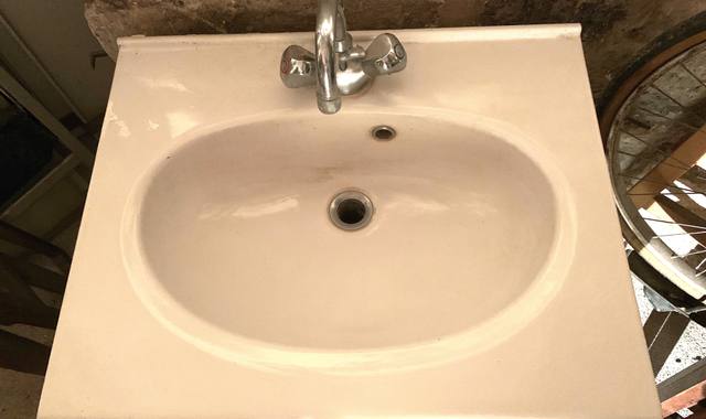 Mobilier lavabo en porcelaine blanche, vasque ovale, mitigeur, siphon.