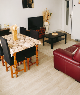 Mobilier dans un canapé couleur rouge vin en cuir, et d'une table avec 4 chaises